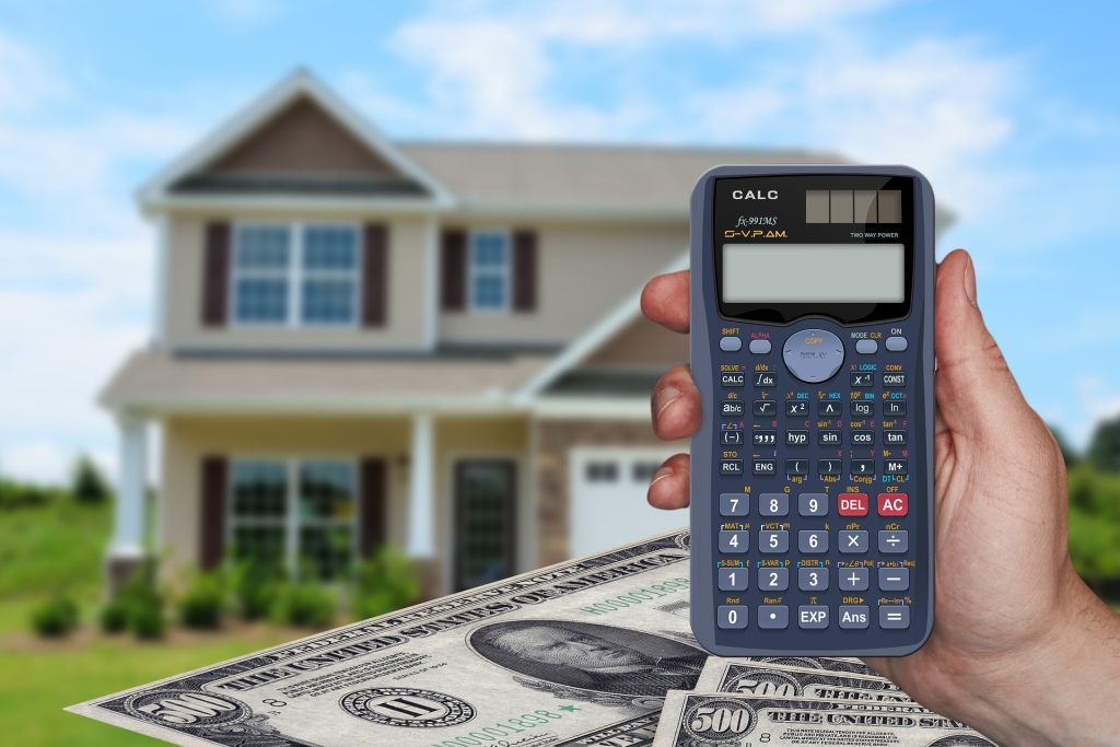 Calculator with house and money in background